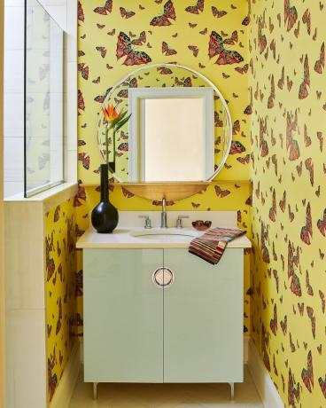 bagno di servizio con mobile lavabo color menta e carta da parati a farfalla