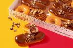 Krispy Kreme ha appena svelato tre ciambelle Twix e una è farcita con una barretta di cioccolato a grandezza naturale