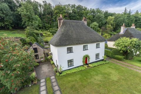 cottage dal tetto di paglia con un esterno bianco è in vendita in un pittoresco villaggio di Dorset