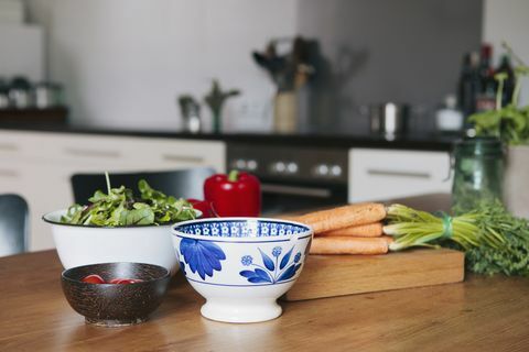 Verdure e ciotole sulla tavola di legno in cucina