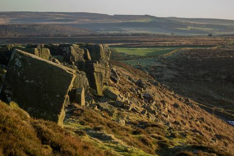 Vista del paesaggio che include una parete rocciosa sul bordo del marciapiede nel Peak District, Regno Unito