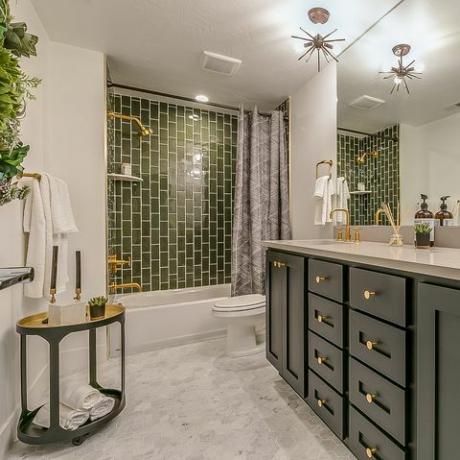 il verde è il tema di questo bellissimo bagno con rubinetti e sanitari in ottone