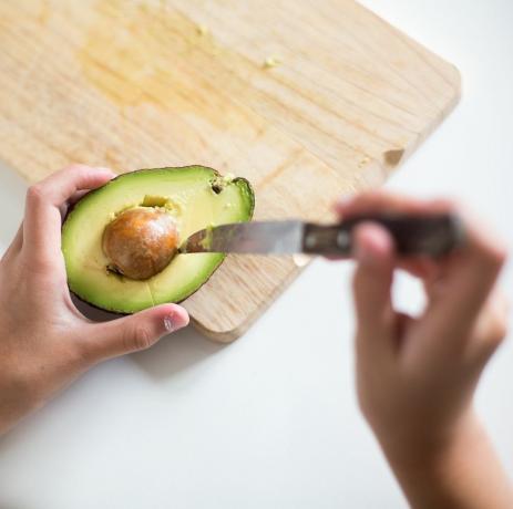 ragazzo che estrae il nocciolo da un avocado