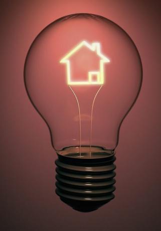 Una lampadina a casa singola contiene un filamento incandescente a forma di casa che indica energia, elettricità e problemi verdi