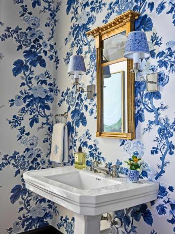 lavabo bianco e pareti ricoperte di carta da parati a fiori blu