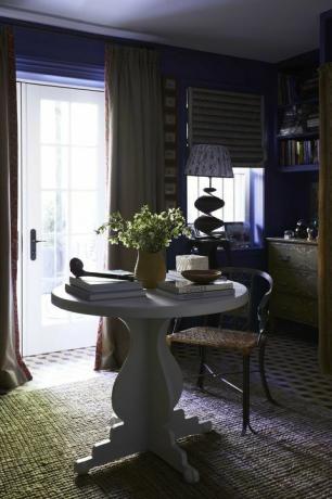salotto blu, parete dipinta di blu, tavolo circolare bianco, libri sul tavolino da caffè