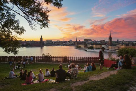 La gente che ha picnic in un parco con panorama di Stoccolma durante il tramonto, Svezia