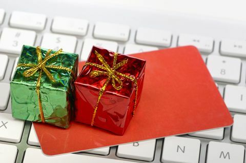 Acquisto online di concetto di festa - contenitori di regalo miniatura e carta di credito o regalo sopra la tastiera di computer.