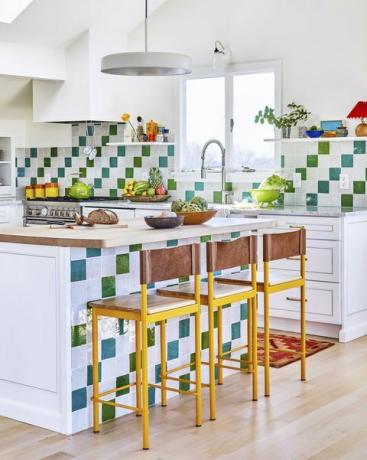 cucina con piastrelle bianche blu e verdi, piano di lavoro in legno