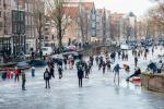 I pattinatori su ghiaccio scivolano sui canali ghiacciati di Amsterdam durante il grande congelamento dell'Europa