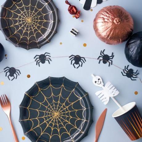 Piatti per feste di Halloween decorati con una ragnatela impreziosita da una lamina di rame lucido.