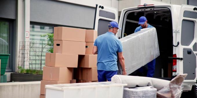 lavoratori di sesso maschile in uniforme blu che scaricano mobili