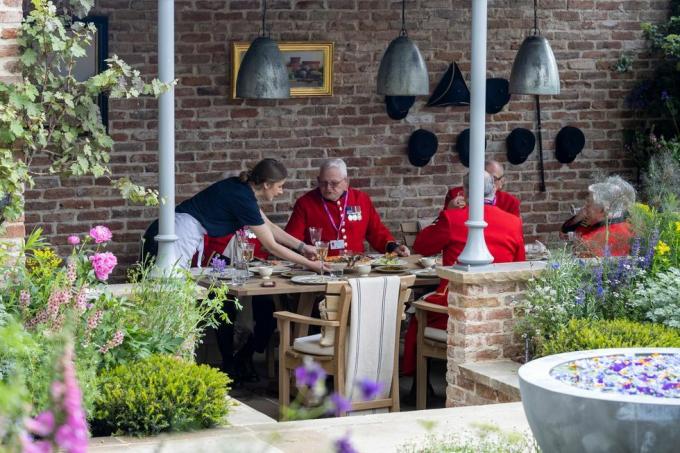 i pensionati di chelsea mangiano a pasto nel giardino di savills progettato da mark gregory sponsorizzato da savills show garden rhs chelsea flower show 2023 stand n. 324