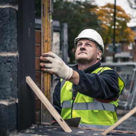 lavoratori che pongono i mattoni sul cantiere