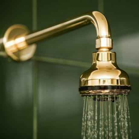 soffione doccia bagno oro metallizzato e acqua corrente