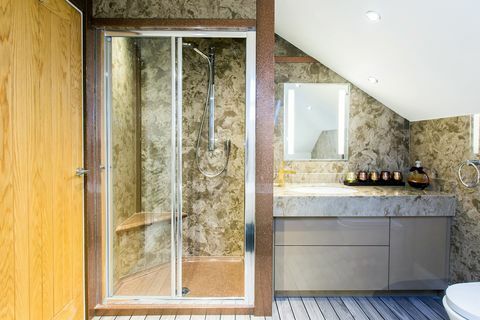 Bagno con pareti in marmo verde e pavimento a strisce