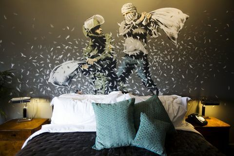 Un dipinto murale di Banksy che mostra un poliziotto di frontiera israeliano e un palestinese in una lotta con i cuscini è visto in una delle stanze del 