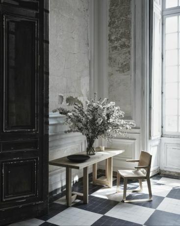 scrivania e sedia con fiori in vaso sopra il tavolo