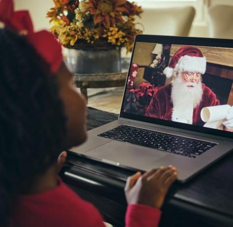 una bambina, parlando con Babbo Natale in una videoconferenza al computer