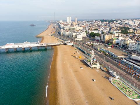 Foto aerea del famoso molo di Brighton e dell'oceano situato nella costa meridionale dell'Inghilterra nel Regno Unito che fa parte della città di Brighton e Hove, scattata in una luminosa giornata di sole che mostra le giostre della fiera