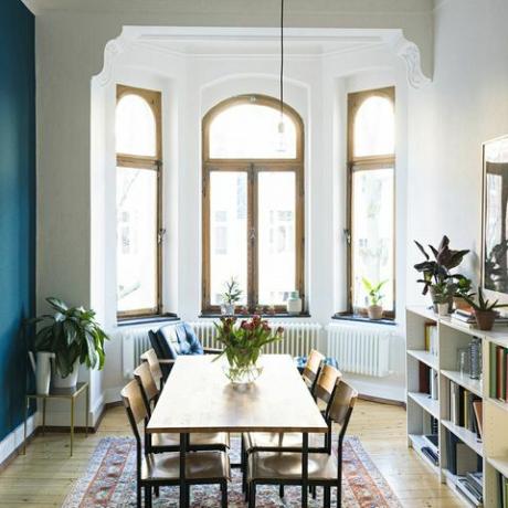 Tavolo e sedie in legno nel moderno salotto con grande vetrata in elegante appartamento