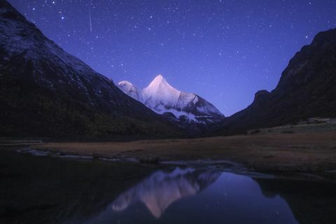 una meteora orionide si posa sulla montagna innevata di jampayang in Cina