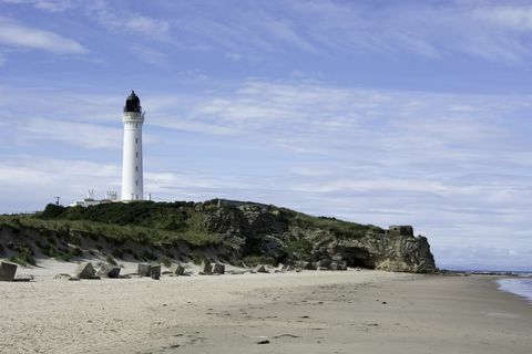 Scena costiera con faro e grotte marine