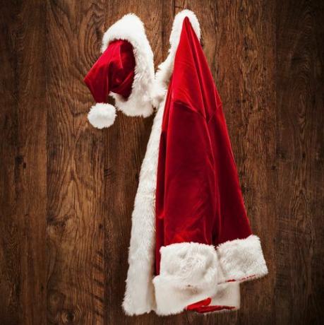 costume di Babbo Natale appeso a una parete di legno girato con una lente inclinata e uno spostamento