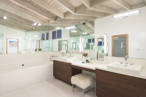 bagno moderno con armadi marroni e un grande specchio