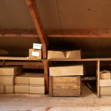 vecchio sottotetto in legno interno con vecchie scatole di cartone per la conservazione o lo spostamento, primo piano