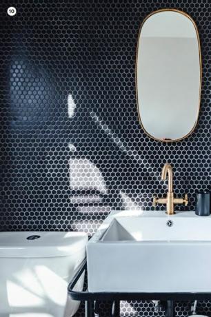 vanità del bagno con muro di piastrelle blu e specchio ovale