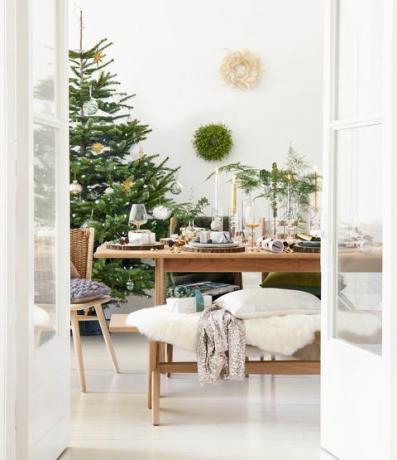 foto di copertina, tavolo da pranzo in legno con un albero di natale nell'angolo della stanza