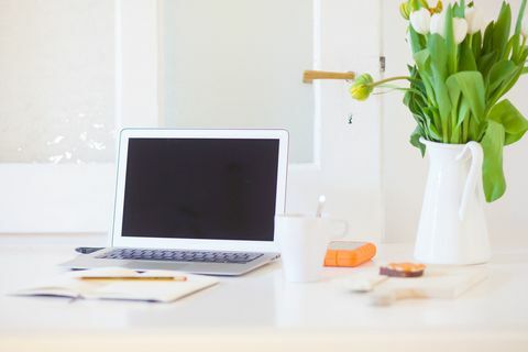 Lavorare da casa. Computer portatile su una scrivania in un salotto o cucina moderna. Ufficio a casa