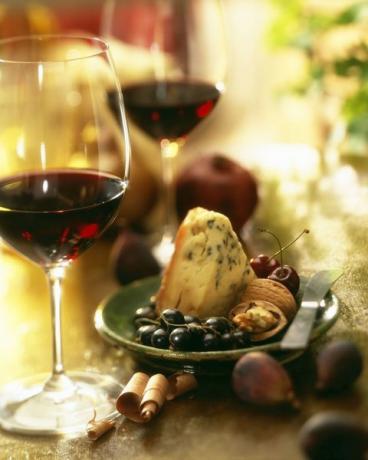 Vino rosso con antipasto piatto di gorgonzola, uva, noci e fichi