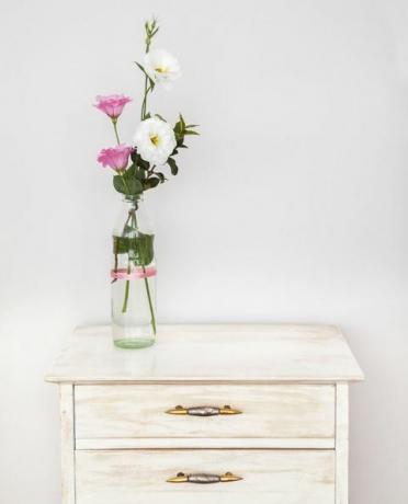 Mobili riciclati con bouquet di fiori di lisianthus contro il muro bianco