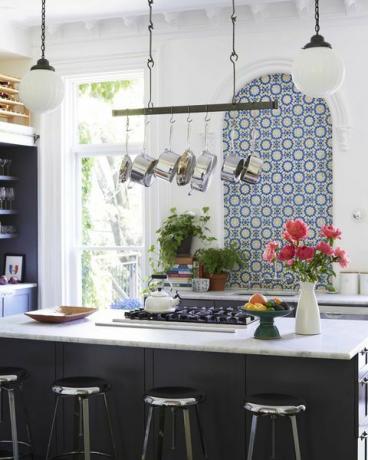 cucina, isola cucina nera, sgabelli da bar in acciaio inossidabile, ripiani in marmo bianco, griglia nera, piastrelle blu e gialle