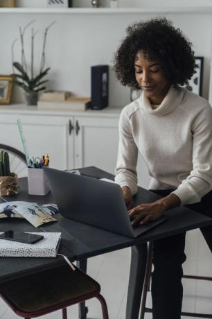 donna che lavora nel suo ufficio a casa utilizzando un computer portatile