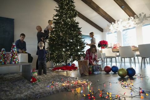 Famiglia che decora l'albero di Natale in salone