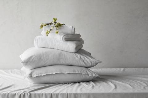 pila di biancheria da letto di cotone turco sul letto