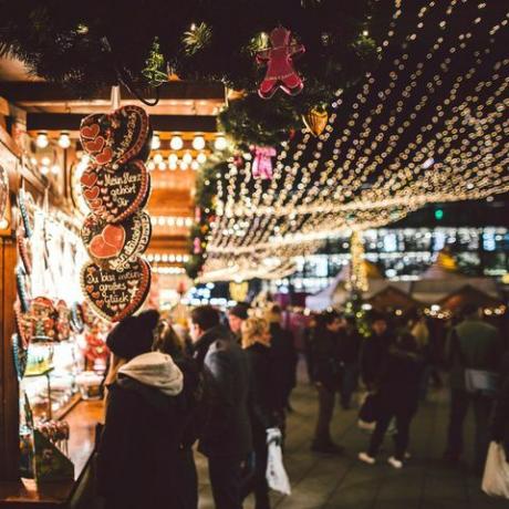 persone per strada di notte durante il periodo natalizio