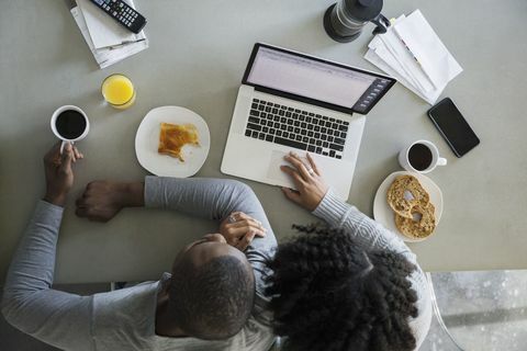 Vista sopraelevata delle coppie al computer portatile in cucina