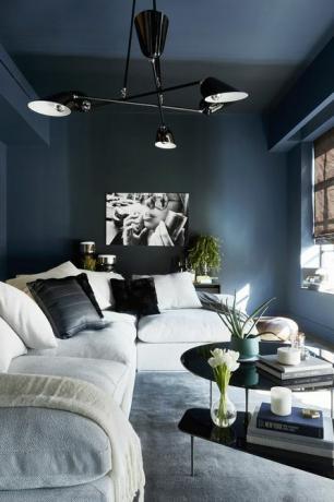 per un effetto ombré, una sala di intrattenimento è stata dipinta nel blu rigido di Farrow Ball e il divano con ringhiere di designlush chandelier di zia priven