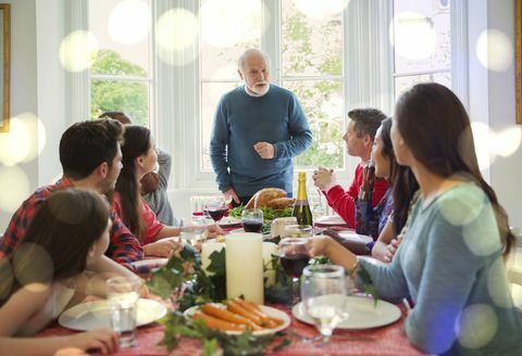 Nonno in procinto di intagliare il tacchino di Natale a tavola