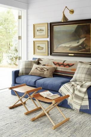 soggiorno rustico con divano blu, sgabelli in pelle e opere d'arte di pesci
