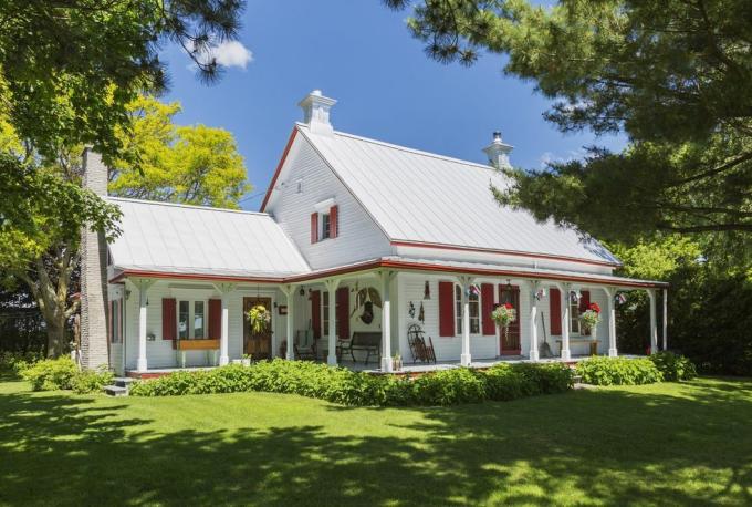 vista esterna di circa 1840 casa bianca in stile canadese all'inizio dell'estate, quebec, canada