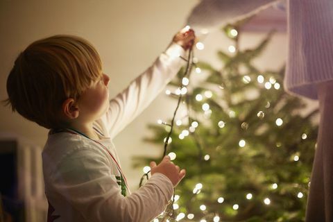 come appendere le luci di natale ragazzo che mette insieme le luci